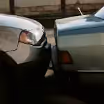 A close-up view showing the aftermath of a rear-end car collision in an outdoor setting.