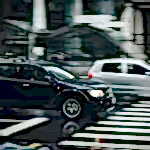 Vehicles speeding through a city street with a visible zebra crossing and blurred motion effect.